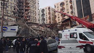 Спасатели и медицинские бригады пытаются добраться до жителей, оказавшихся в ловушке в разрушенном здании после землетрясения в Диярбакыре, юго-восточная Турция.