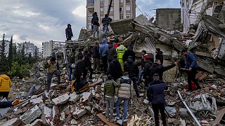 يبحث الناس وفرق الطوارئ عن أشخاص في مبنى مدمر في أضنة، تركيا، 6 فبراير 2023.