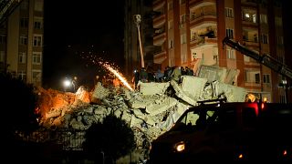 Emergency team members search for people in a destroyed building in Adana, Turkey on Tuesday evening.