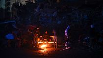 Sobreviventes aquecem-se numa fogueira em Kahramanmaras, na Turquia