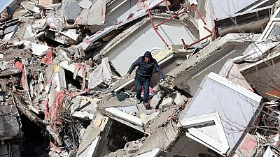 Habitante desce pelos escombros de um prédio, em Kahramanmaras, na Turquia