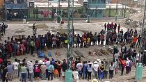 أشخاص يقفون حول جثث الذين لقوا حتفهم في الانهيارات الأرضية الأخيرة في كامانا، بيرو، 6 فبراير 2023.