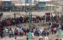 In Camana betrachten Menschen die sterblichen Überreste von Opfern des Erdrutsches