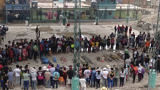 Residents stand around the bodies of persons who perished in recent landslides in Camana, Peru, Monday 6 February, 2023