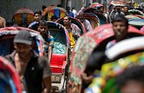 Rickshaw pullers wait in a line, awaiting passengers in Dhaka, Bangladesh