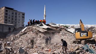 People work at the site of a collapsed building, in the aftermath of a deadly earthquake in Kahramanmaras, Turkey February 8