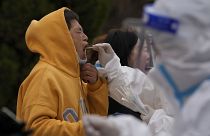 مواطن في موقع لفحص فيروس كورونا بالقرب من المباني السكنية، خلال إتباع  السلطات الصينية لسياسة "صفر كوفيد" أبريل / نيسان 2022، بكين، الصين.