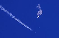  بقايا بالون كبير ينجرف فوق المحيط الأطلسي، قبالة ساحل ولاية كارولينا الجنوبية، ورؤية طائرة مقاتلة ونفاثها تحته، 3 فبراير 2023.