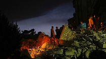 Emergency team members search for people in a destroyed building in Adana, Turkey, Tuesday, Feb. 7, 2023.