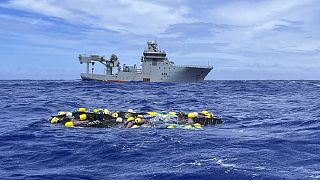 شحنة الكوكايين تطفو على سطح المحيط الهادئ مع السفينة الملكية النيوزيلندية البحرية خلفها. 2023/02/08