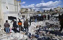 People search through the rubble of collapsed buildings where a newborn girl was found in the town of Jinderis, Aleppo province, Syria, 7 February 2023