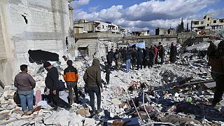 People search through the rubble of collapsed buildings where a newborn girl was found in the town of Jinderis, Aleppo province, Syria, 7 February 2023