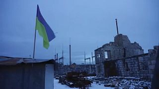 Ukrainian flag flown among the destroyed buildings