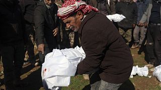 Mourners bury family members who died in a devastating earthquake that rocked Syria and Turkey at a cemetery in the town of Jinderis, Aleppo province, Syria, Feb. 7, 2023.