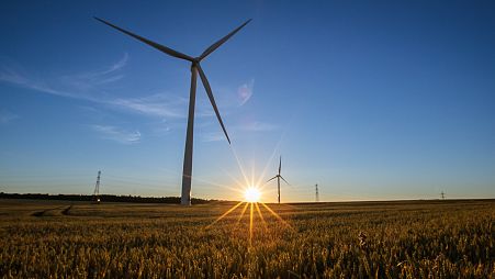 Wind turbines in operation as the sun sets over Hook Moor Wind Farm in Leeds.