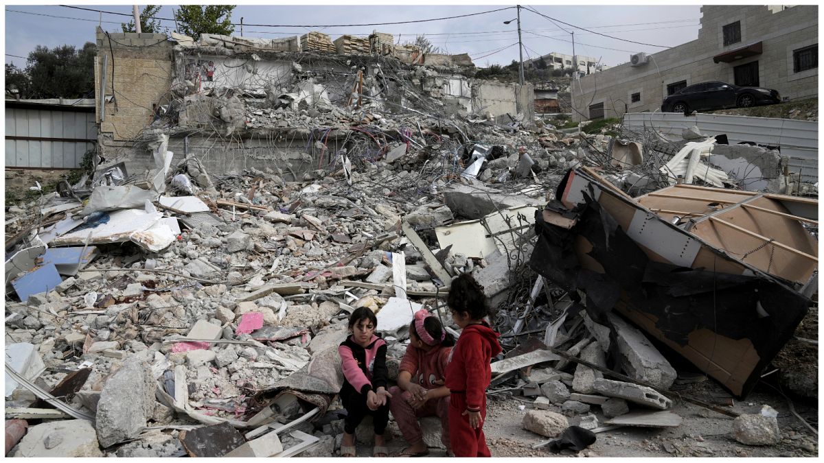 فتيات من عائلة مطر يجلسن بالقرب من أنقاض منزلهن الذي كان يؤوي 11 شخصًا قبل أن تهدمه السلطات الإسرائيلية في حي جبل المكبر في القدس الشرقية