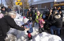 أباء وأطفالهم أثناء انتظارهم للأخبار بعد اصطدام حافلة بمركز للرعاية النهارية في لافال، كيبيك، يوم الأربعاء، 8 فبراير/شباط 2023.