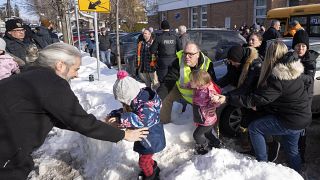 أباء وأطفالهم أثناء انتظارهم للأخبار بعد اصطدام حافلة بمركز للرعاية النهارية في لافال، كيبيك، يوم الأربعاء، 8 فبراير/شباط 2023.