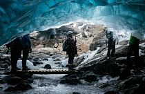 Tourists visit a waterfall ice cave on the Breidamerkurjokull Glacier in Iceland.