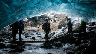 Tourists visit a waterfall ice cave on the Breidamerkurjokull Glacier in Iceland.