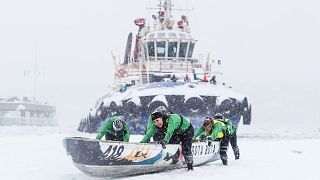 A team pushes their canoe on the ice during the Quebec Winter Carnival Ice Canoe Race in Quebec City, Canada.