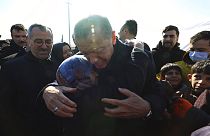 Turkey's President Recep Tayyip Erdogan and a survivor hug each other as he visits the Kahramanmaras city center destroyed by Monday's earthquakes