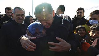 Turkey's President Recep Tayyip Erdogan and a survivor hug each other as he visits the city center destroyed by Monday earthquake in Kahramanmaras, southern Turkey,