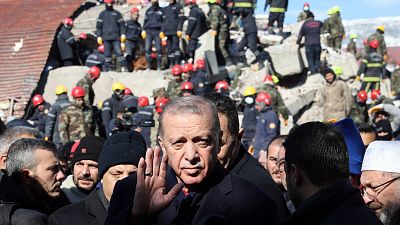 Turkish President Recep Tayyip Erdogan tours the site of destroyed buildings during his visit to the city of Kahramanmaras in southeast Turkey.