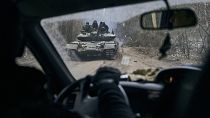 Ukrán tank katonákkal egy autó ablakán keresztül az ukrajnai Luhanszk régióban 2023. január 15-én.