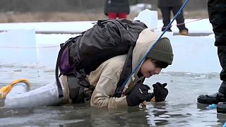 أطفالٌ سويديون يتعلمون في مياه بحيرة رافالين المتجمدة شمال العاصمة ستوكهولم، كيفية التصرف في حال السقوط في بحيرات وبرك متجمدة