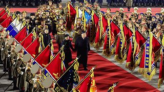 North Korean leader Kim Jong Un, center right, reviews an honor guard with his daughter, center left, and his wife Ri Sol Ju during a military parade