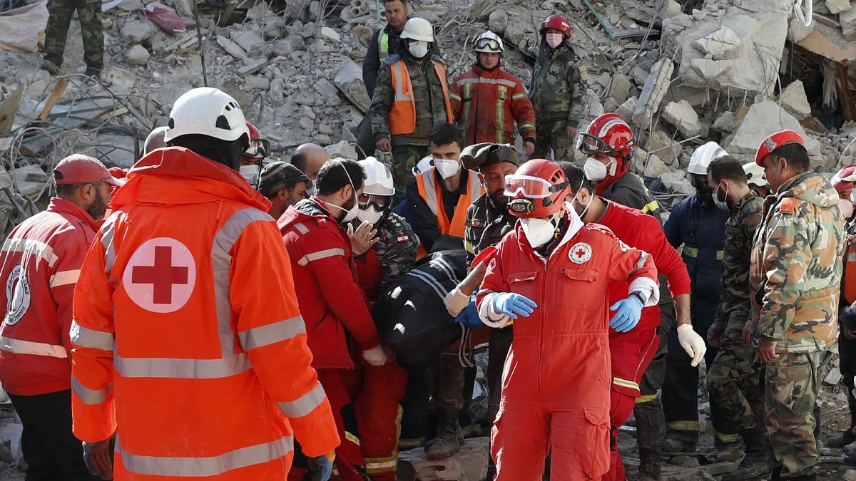 Rescue teams carry the body of a victim from a destroyed building after a devastating earthquake rocked Syria and Turkey, in the costal town of Jableh, Syria, Feb. 9 2023