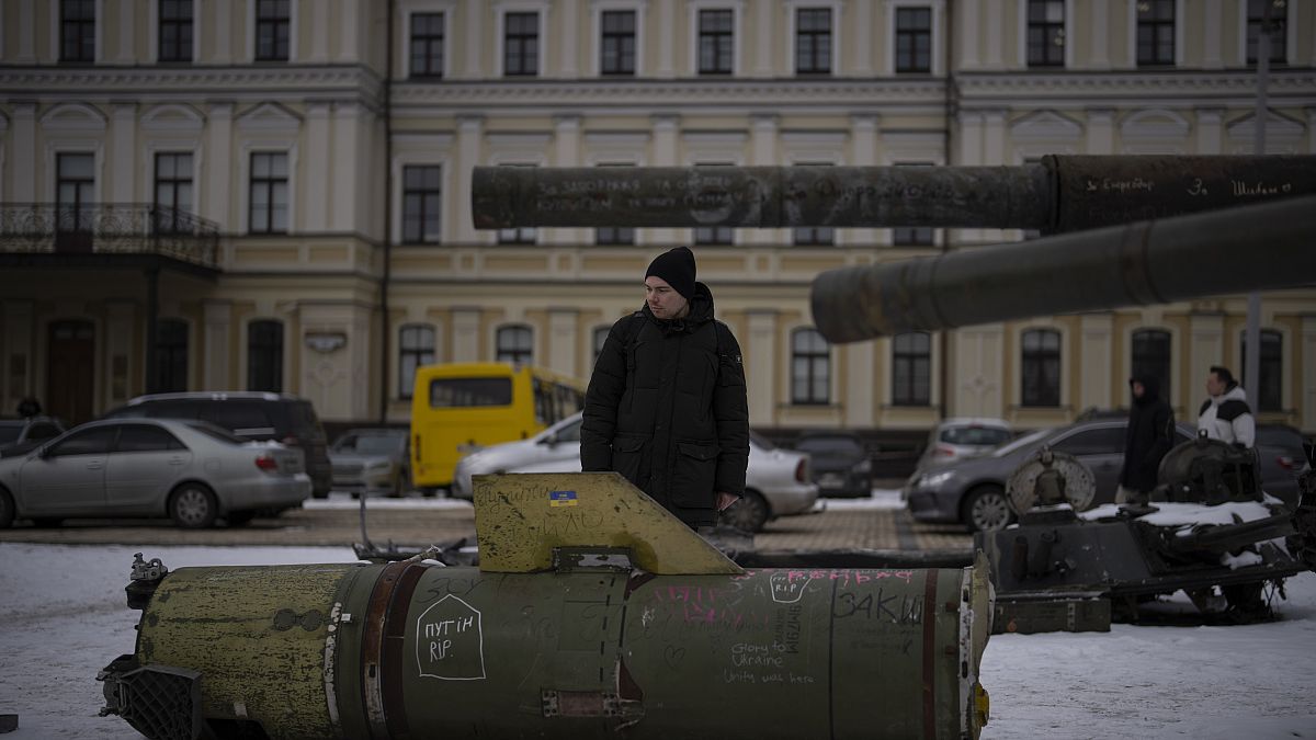 Egy férfi egy orosz rakéta maradványait nézi Kijev központjában 2023. február 7-én
