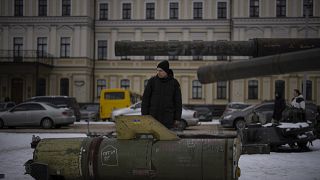 Egy férfi egy orosz rakéta maradványait nézi Kijev központjában 2023. február 7-én