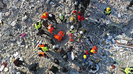 Rescue teams search for people in a destroyed building in Antakya, southeastern Turkey, Friday, Feb. 10, 2023. 