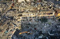 تبحث فرق الإنقاذ عن أشخاص بينما تقوم حفارة بإزالة الأنقاض من مبنى مدمر في أنطاكيا، جنوب شرق تركيا، 10 فبراير 2023.