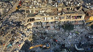تبحث فرق الإنقاذ عن أشخاص بينما تقوم حفارة بإزالة الأنقاض من مبنى مدمر في أنطاكيا، جنوب شرق تركيا، 10 فبراير 2023.