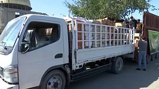 Önkéntesek adományokat pakolnak egy teherautóra Bagdadban.