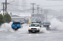 Cars move through flooded roads in the northern New Zealand city of Whangarei as Tropical Cyclone Gabrielle hits the Northland, Sunday, Feb. 12, 2023.