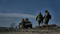 سربازان ارتش اوکراین در حال حرکت به سمت خودروی زرهی «هامِر» آمریکایی در موقعیتی نزدیک باهموت. شنبه، یازدهم فوریه ۲۰۲۳.