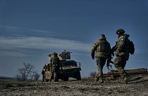 سربازان ارتش اوکراین در حال حرکت به سمت خودروی زرهی «هامِر» آمریکایی در موقعیتی نزدیک باهموت. شنبه، یازدهم فوریه ۲۰۲۳.