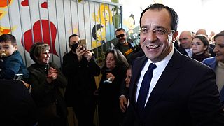 Presidential candidate Nikos Christodoulides smiles as walks with his supporters after casting his vote during the presidential elections, February 12 2023