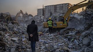 A man stands on top of the rubble of his house destroyed during an earthquake in Antakya, southeastern Turkey, Sunday, Feb. 12, 2023