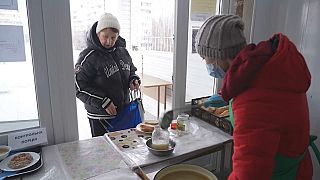  Volunteers give out food to residents in Saltivka. 