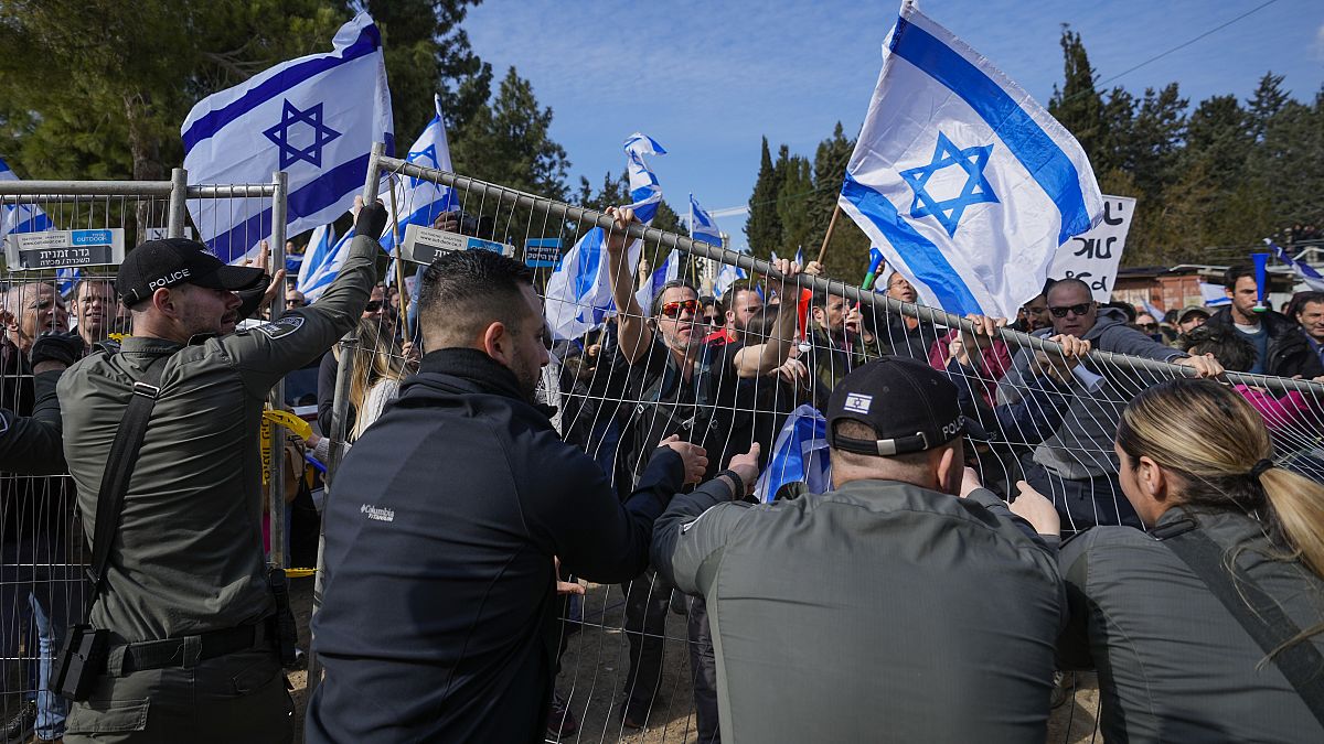 Протестующие пытаются прорваться через полицейское оцепление во время митинга против планов правительства реорганизовать судебную систему, Иерусалим, 13 февраля 2023 года.