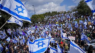 Israelis wave national flags during protest against plans by Prime Minister Benjamin Netanyahu's new government to overhaul the judicial system,