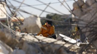 فتى فلسطيني على أنقاض منزله بعد أن دمره الجيش الإسرائيلي في مدينة جنين الضفة الغربية.