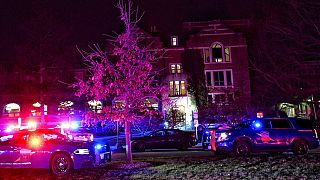 Emergency vehicles block an entrance to Michigan State University Monday night.