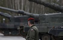 A Polish soldier walks next to the Leopard 2 tanks during a training at a military base and test range in Swietoszow, Poland, Feb. 13, 2023. 