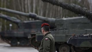 A Polish soldier walks next to the Leopard 2 tanks during a training at a military base and test range in Swietoszow, Poland, Feb. 13, 2023. 